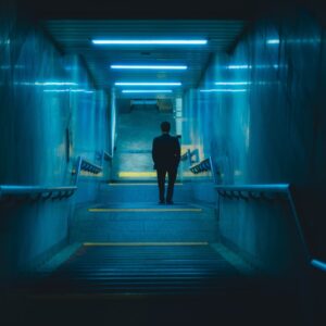 A man is walking down a dark hallway