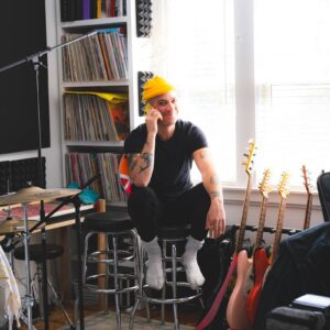 A man sitting in a room with a guitar