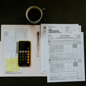 Mesa com celular, caneta e documentos fiscais para conferência financeira
