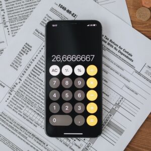 Calculadora sobre documentos fiscais em uma mesa de trabalho