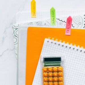 Calculadora e documentos fiscais sobre mesa de trabalho para organização de obrigações do Simples Nacional