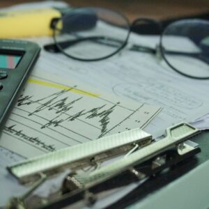 Mesa de trabalho com calculadora, documentos e materiais financeiros para análise contábil