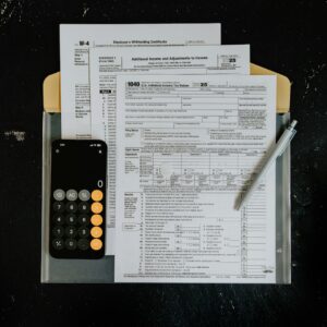 Formulários fiscais, calculadora e caneta sobre mesa para organização da rotina fiscal mensal