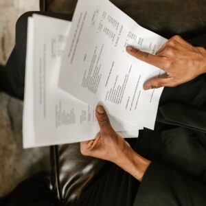 Profissional conferindo documentos financeiros e notas em mesa de trabalho