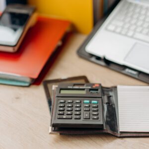 Mesa de trabalho com laptop, calculadora e documentos para rotina financeira