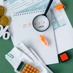 Documentos fiscais, calculadora e materiais de escritório sobre uma mesa